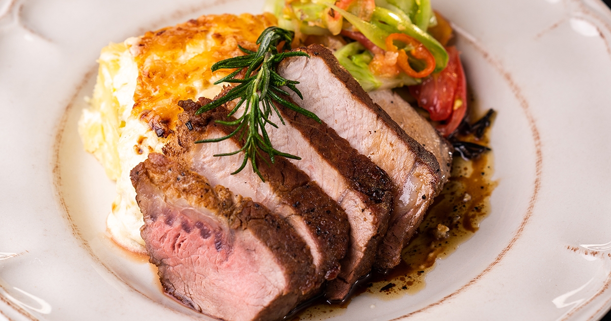 Póréhagymás rakott krumpli sertésbélszínnel, zöldparadicsom-salátával